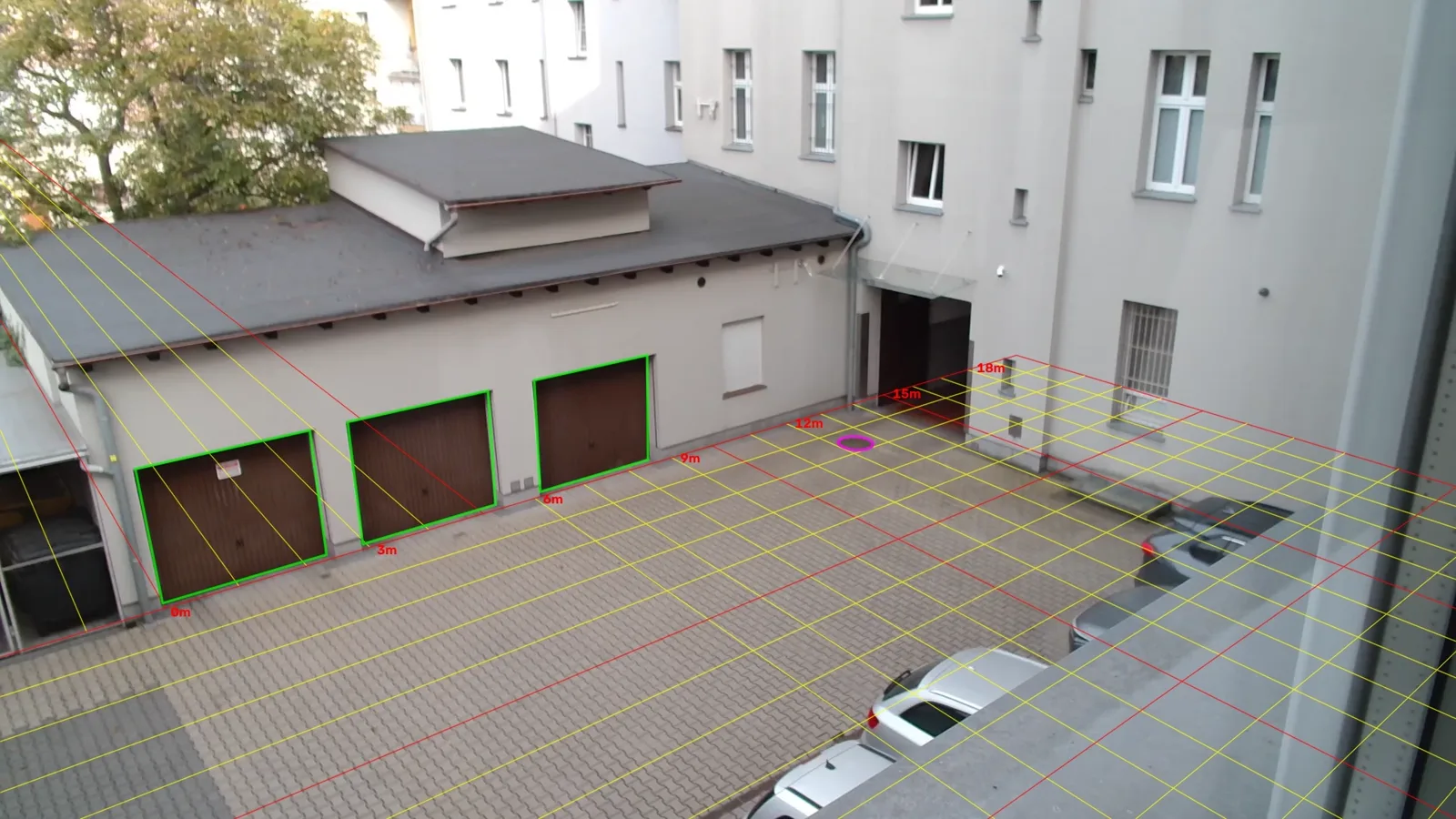 Real camera frame of the courtyard with a 1 metre grid drawn on the ground and the garage doors outlined